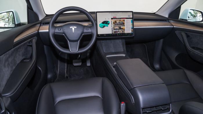 Στη minimal καμπίνα του Tesla Model Y οι φυσικοί διακόπτες λάμπουν δια της απουσίας τους, πέρα από δύο ροδέλες στο τιμόνι και τα αλάρμ εκεί που σε άλλα αυτοκίνητα είναι η πλαφονιέρα.